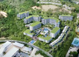 An aerial view of apartment construction in Phuket, surrounded by greenery and palm trees.