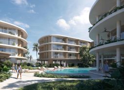Apartment construction in Surat Thani with rounded buildings and a pool in the middle of the complex.