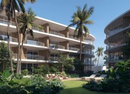 Apartment buildings in Surat Thani: apartment buildings with palm trees and greenery in the background.