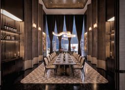 A luxurious dining room with a long table and a view of the city in an apartment development.