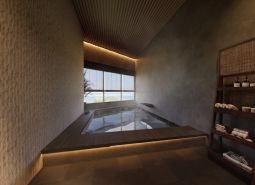 Bathroom with a whirlpool, wooden decor flooring, shelf with towels and cosmetics.