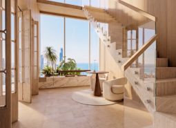 Interior with wood-patterned flooring and staircase, ocean view. Apartment construction.