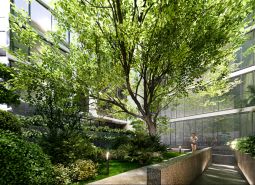 Apartment construction in Phuket with lush greenery and glass facades of buildings.