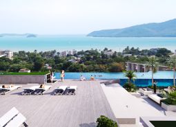 Apartment construction in Phuket with a pool and views of the sea and greenery.