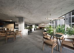 A bright bistro with tables and chairs, indoor plants, apartment construction.