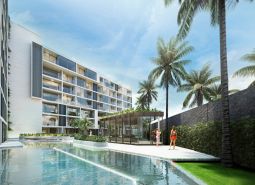 Apartment construction in Phuket with a pool and palm trees in the background.
