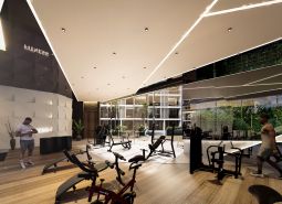 The interior of a gym with wood-patterned flooring and exercise machines. Apartment construction.