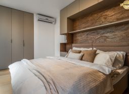 Bedroom with a double bed, built-in wardrobes, and a floor with a wooden decor. Apartment construction.