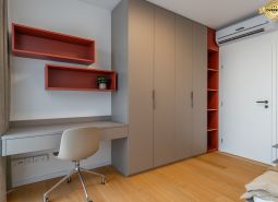 Interior with an office desk, storage cabinets, and a wood-patterned floor. Apartment construction.