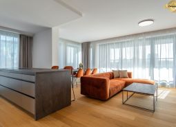 Living room with an orange sofa, wood-patterned floor, and a table in the living room.