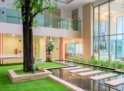 Interior with a spacious garden, lawn, and water features in the construction of apartments.