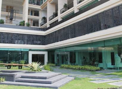 Apartment construction in Pattaya with glass facades and balconies with plants.