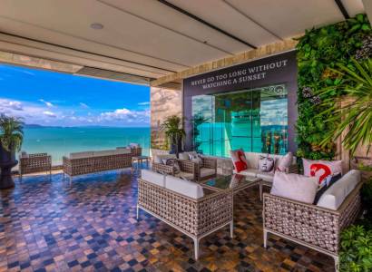 Apartment construction with terrace and sea view in Pattaya, comfortable seating and greenery.