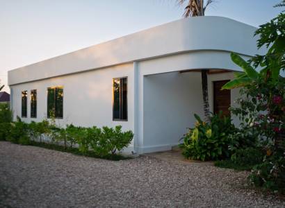 Construction of houses in Paje, Unguja South Region, with greenery around the white structure.