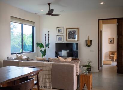 Interior with a sofa, television, and wooden furniture under construction of houses.