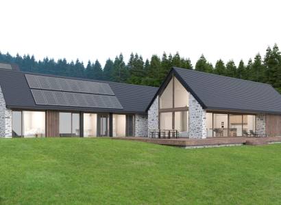 Stone house in Tajov with photovoltaic panels on the roof, surrounded by forest. Development plots.