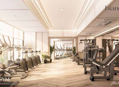 Indoor gym with wood-patterned flooring and fitness equipment in an apartment development.