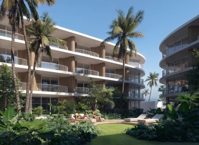 Apartment buildings in Surat Thani: apartment buildings with palm trees and greenery in the background.