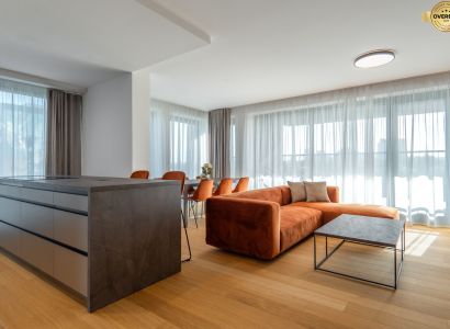 Living room with an orange sofa, wood-patterned floor, and a table in the living room.