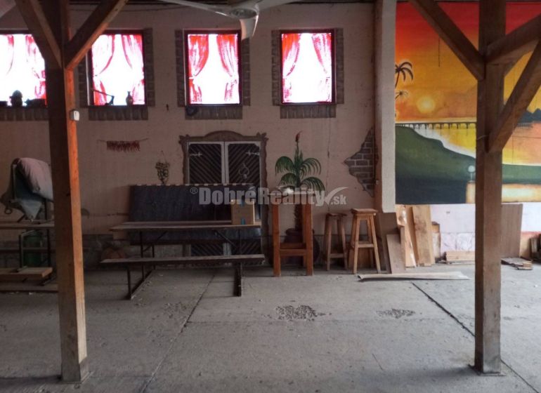 Interior of commercial spaces with furniture, wooden columns, and an artistic mural on the wall.