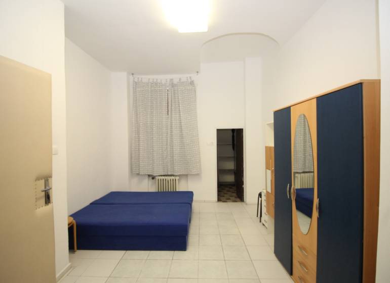 Bright 1-room apartment with a blue bed, wardrobe, and white tiles.