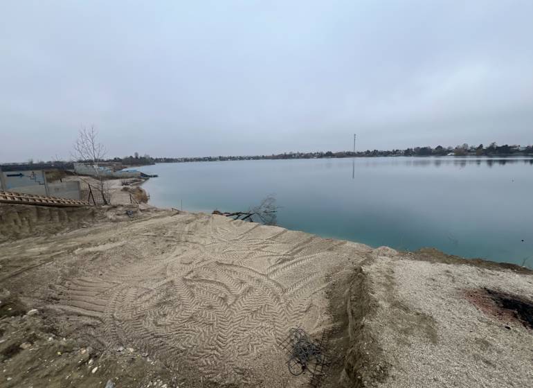 A lake surrounded by a sandy shore, on Veľké Košariská Street, Recreational plots.