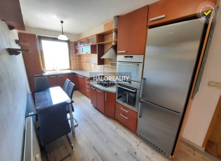 A kitchen in a 4-room apartment with built-in appliances and a dining table.
