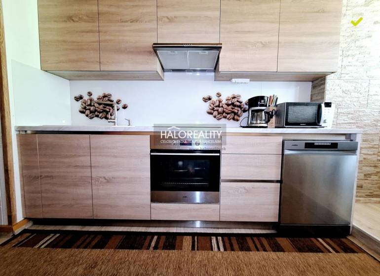 A kitchen in a 2-room apartment with wooden cabinets, an oven, a microwave, and wall decoration.