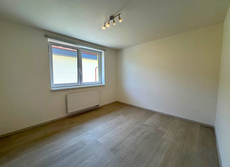 A bright room with a window and wooden floor in a 3-room apartment.