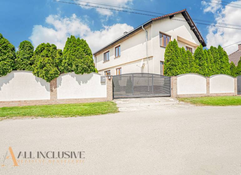 A family house in Sapa with a white facade, a gate, and trees in the front garden.