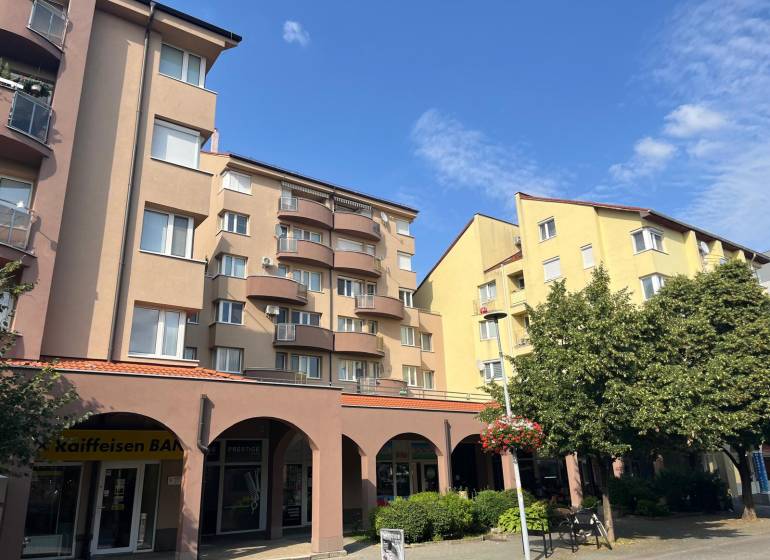 Buildings with commercial spaces on Lichnerova Street in Senec surrounded by greenery.