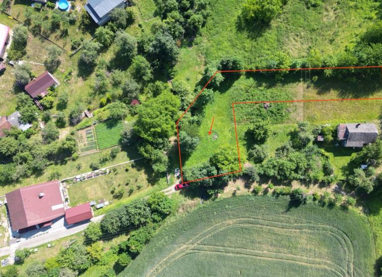Aerial view of a residential plot in the village of Visolaje surrounded by greenery and houses.