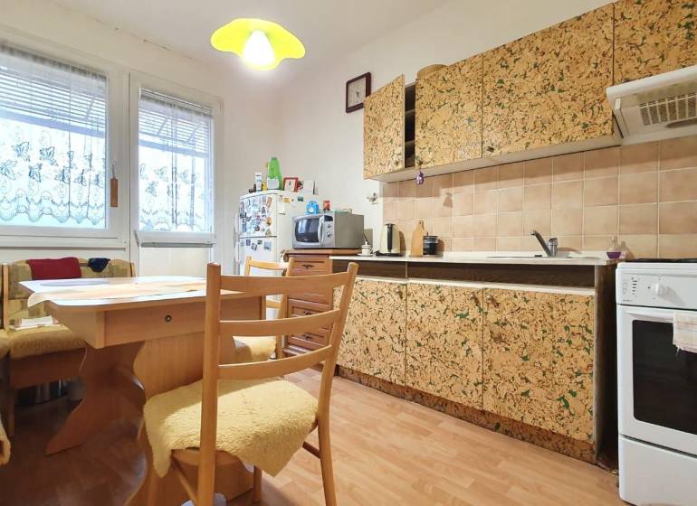 A kitchen in a 3-room apartment with wooden furniture and patterned cabinets.