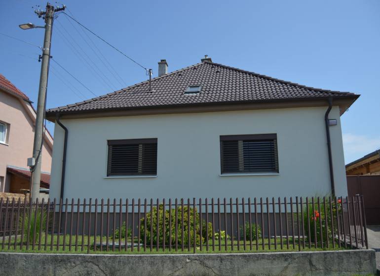 A family house in Trstín with a fence and a garden.