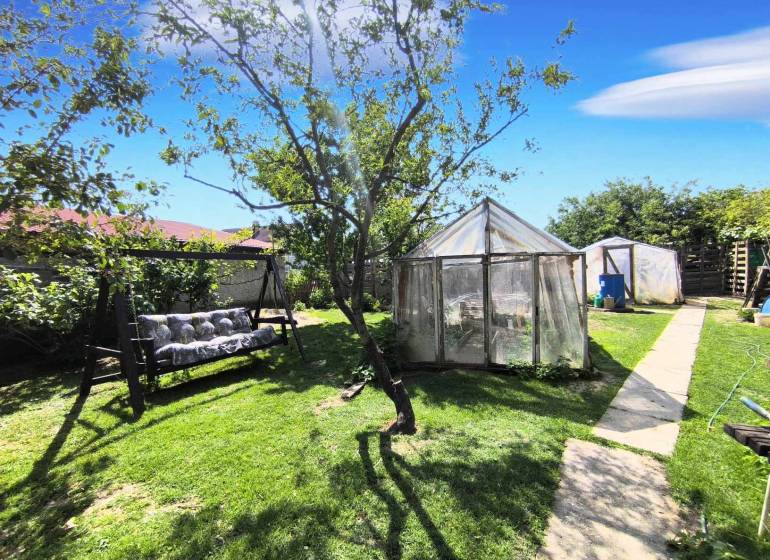 The garden of a family house in Partizánske - Malé Bielice area, on the street, with a swing and greenhouses.