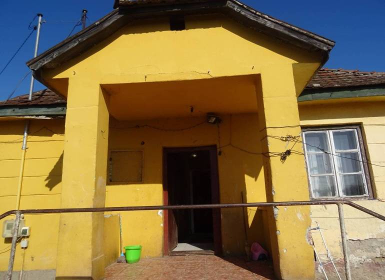 A family house in Vilmany with a yellow facade and a smaller concrete entrance area.