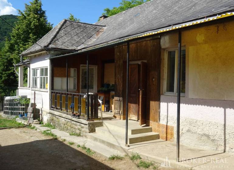 A family house in Pusztafalou with a veranda, garden, and stone foundation.