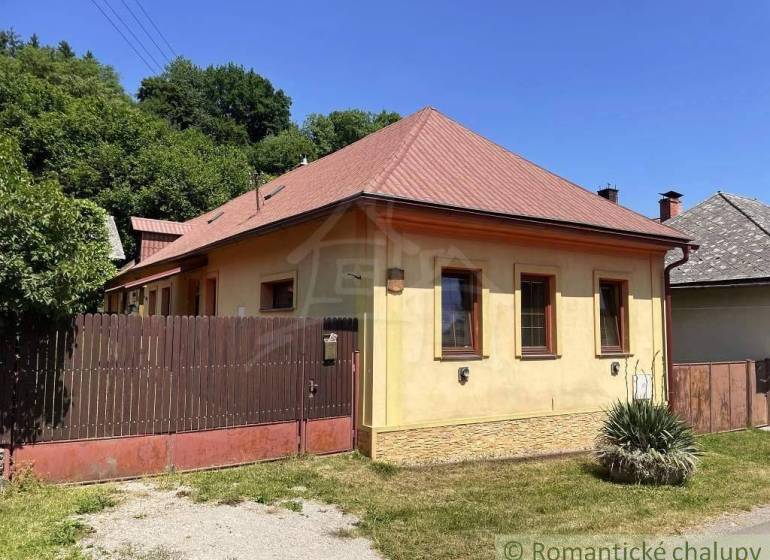 A family house in Medzev with a brown roof and a wooden fence on Green Street.