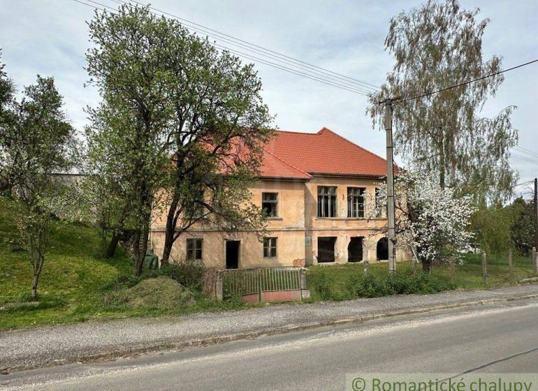 A family house in Rimavská Sobota with trees, in front of which there is a road and a fence.