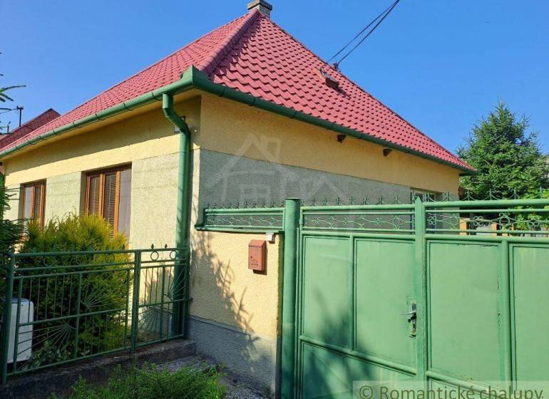 A family house in Dvorníky with a red roof and a green gate.