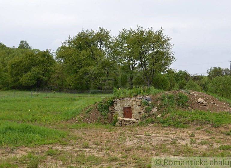 Gardens in Kečkovce with a stone cellar surrounded by grass and trees.