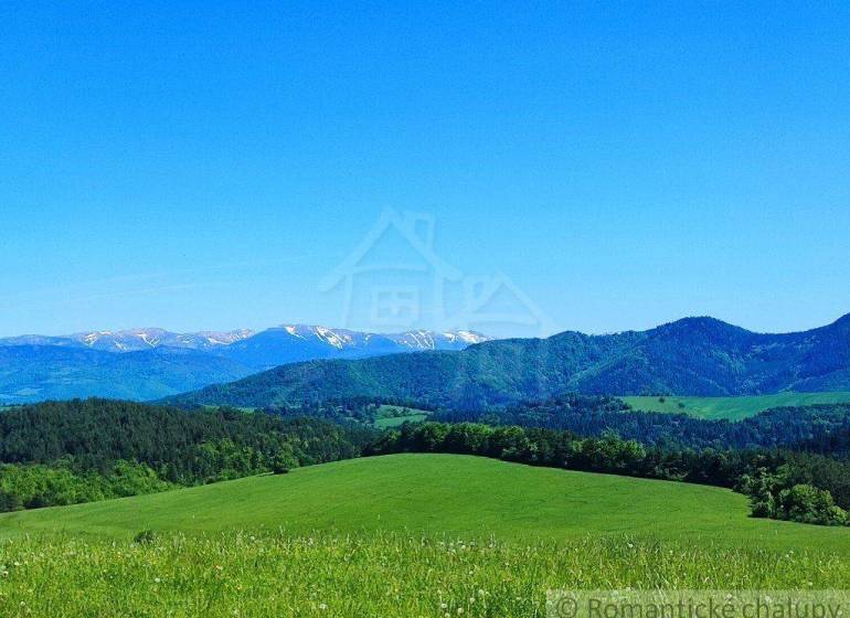 Peaceful landscape, hills, mountains with snow, meadows, trees, blue sky, with gardens.