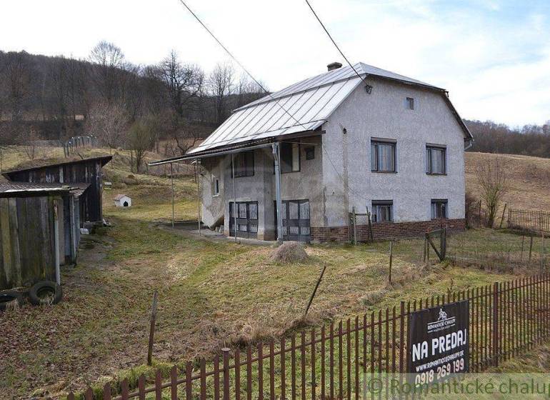 The family house stands on a sloped plot, surrounded by a garden and farm buildings.