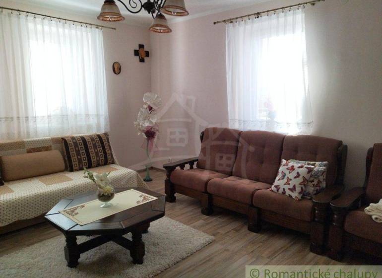 A family house with a cozy living room, wooden furniture, and pleasant decorations in a retro style.