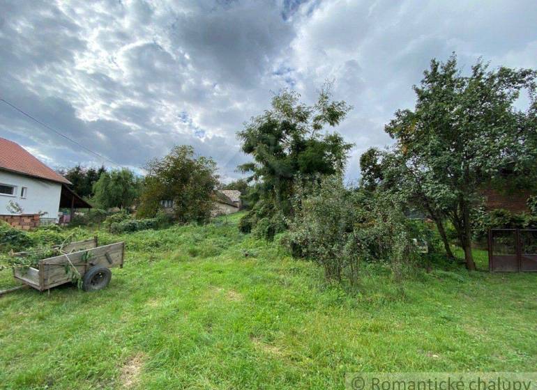 In the picture, there is a country garden and plots with a house and a cart.