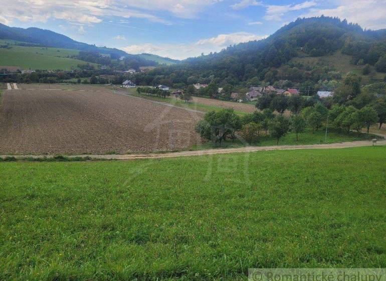 Grassy hills surround fertile fields in a peaceful rural setting near gardens.