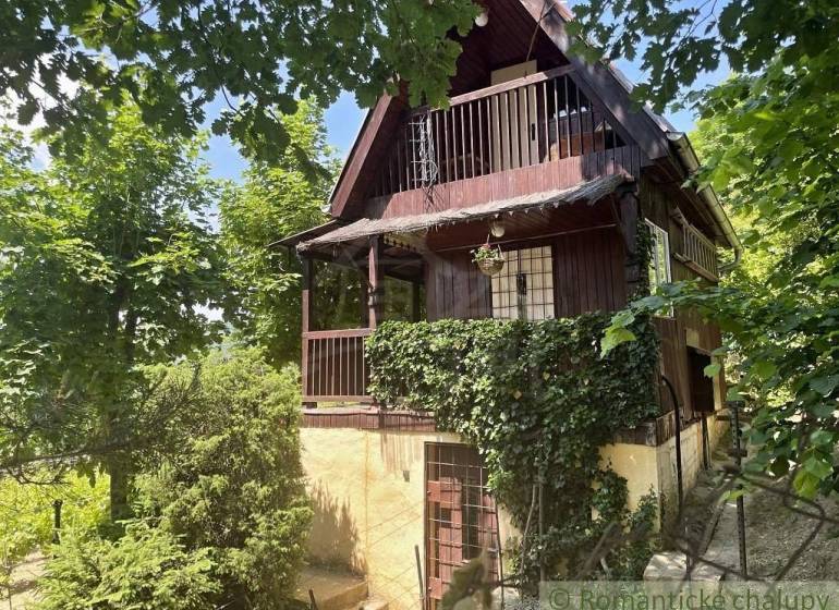 A cottage in Jablonov nad Turňou surrounded by greenery, with a wooden balcony and climbing plants.