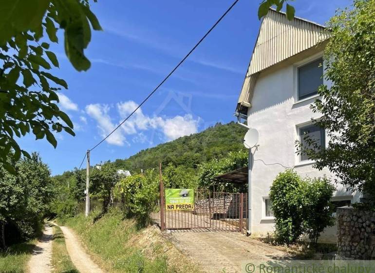 A cottage near Rožňava with a view of the forest road and hilly terrain.