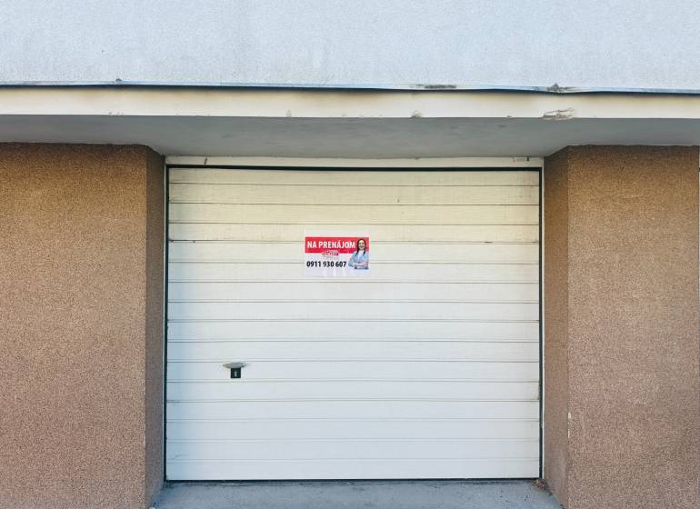 White garage door on Štefánik Square in Spišská Nová Ves with the sign for sale.