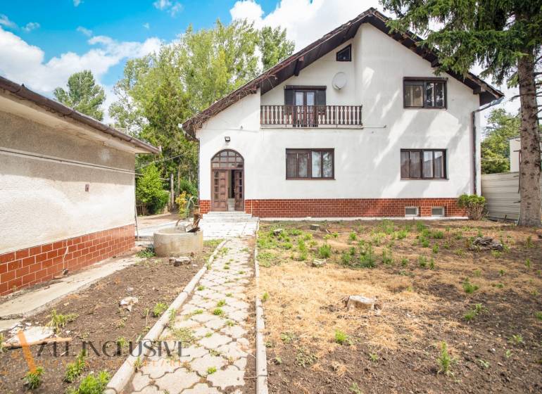 A family house in Žihárec with a white facade, a veranda, and a garden.